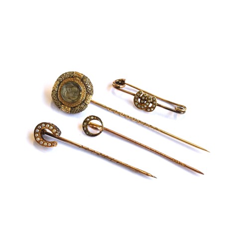 34A - A gold mounted Victorian hair work stick pin, the glazed compartment having plaited hair, surrounded... 