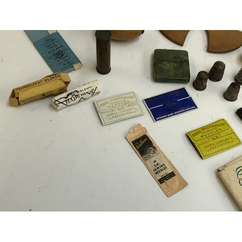 367 - A mixed lot of sewing items to include thimbles, two silver, one with agate top, celluloid cased cot... 