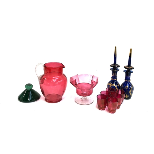 297 - A Victorian green glass paperweight; together with a 19th century cranberry glass jug, shot glasses ... 