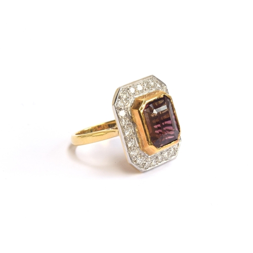 34 - An 18ct gold cluster ring set with an emerald cut bicolour pink tourmaline, approx. 8cts, surrounded... 