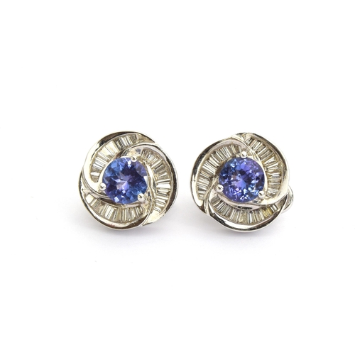 37 - A pair of heavy 18ct white gold earrings set with a central tanzanite, 6.5mm diameter, surrounded by... 