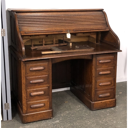 1328 - An oak rolltop desk, with tambour opening to a fitted interior, over a kneehole and eight drawers, 1... 