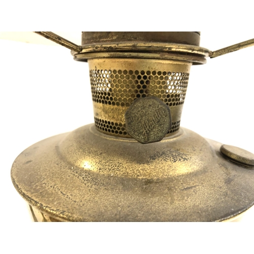 616 - METAL WARES: an oil lamp with chimney and shade together with a French carriage clock (a/f) and a he... 