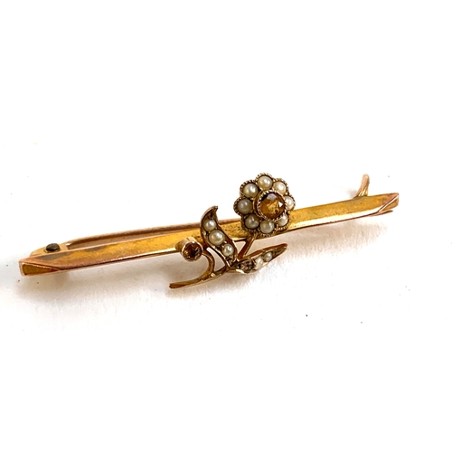 1 - A 9ct gold brooch set with a citrine and seed pearl flower, 4cmW; together with a 9ct gold 'Baby' br... 