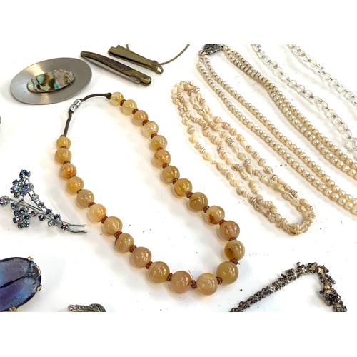 57 - A mixed lot of jewellery to include costume brooches, agate bead necklace, white metal fringe neckla... 