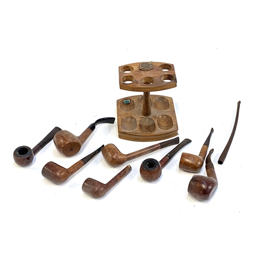 378 - A collection eight tobacco pipes, one with silver collar, with a stand