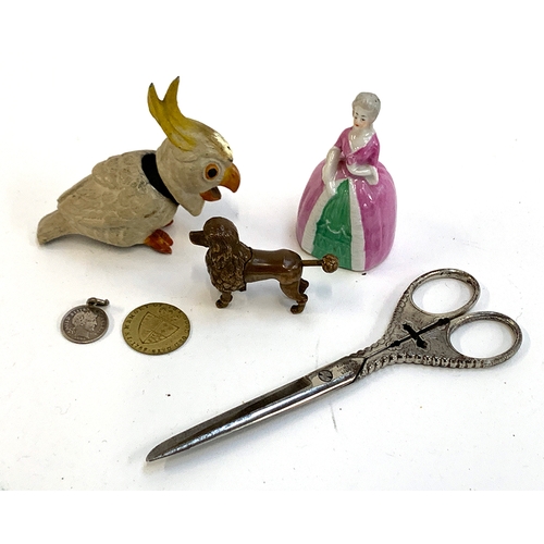 384 - A mixed lot to include a novelty brass poodle cigar cutter; painted spelter budgie; porcelain lady p... 