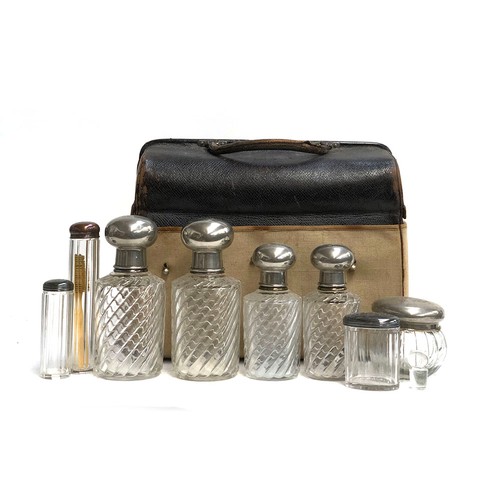 499 - A gent's leather vanity case, with canvas cover, containing a quantity of spirally fluted pots and j... 