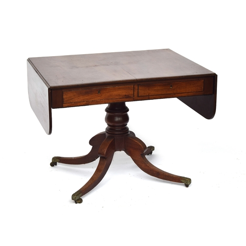 A William IV mahogany sofa table, on a turned column and four swept legs with acanthus caps and brass casters, 93cm wide when closed, 147cm wide when open, 71cm deep, 69cm high