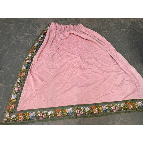 1533 - A pair of lined pink chintz curtains with green floral border, 225cm wide ungathered, 200cm drop