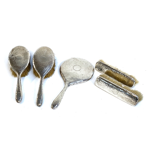 105 - An Edwardian planished silver dressing table set, Chester 1907, comprising two hair brushes, two clo... 