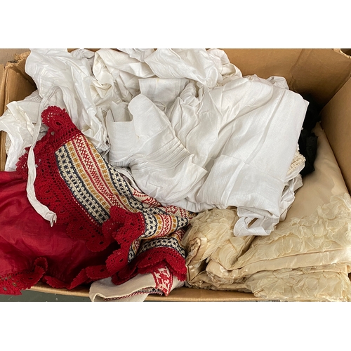 665 - A box of vintage textiles to include cotton aprons, a length of silk; table cloths etc