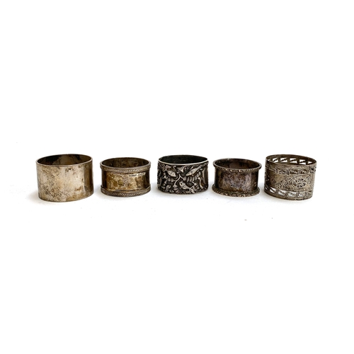 98 - A white metal napkin ring, chased with various fish and crabs; together with four other hallmarked s... 