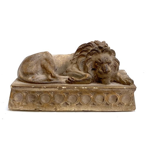 497 - A plaster figure of a recumbent lion, 15x25cm