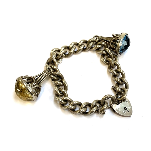 47 - A silver curb link bracelet with heart shaped padlock, with two fob charms, one set with citrine, th... 