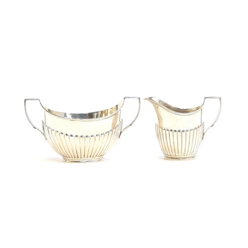 65 - A silver George V milk jug and sugar bowl by William Hutton & Sons, London 1912, each with half gadr... 