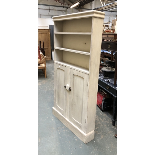 1074 - A limed bookcase, with three shelves over cupboards opening to a further three shelves, 101x20x183cm... 