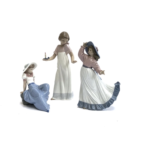 116 - Three Nao by Lladro figures, girl holding candle, no. 1155, 26cmH, girl posing, no. 1391, girl loung... 