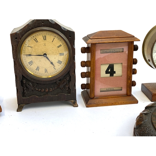 101 - A Maelzel metronome; a early 20th century desk calendar; two clocks; and a carved aneroid barometer