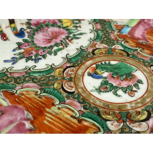 133 - A Chinese famille rose dish of square form, four panels depicting court scenes and flora surrounding... 