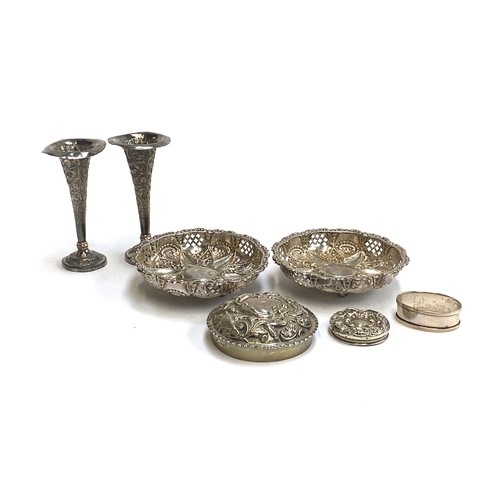 65 - A pair of hallmarked silver chased and pierced bonbon dishes; two chased silver lids; silver napkin ... 