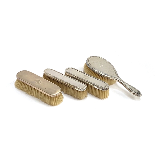 80 - A pair of early 20th century silver backed clothes brushes and hair brush by Finnigans; together wit... 