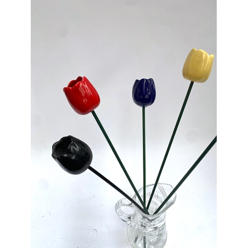 193 - Five ceramic tulips, the longest 53cmL, (one chipped petal), in a cut glass decanter