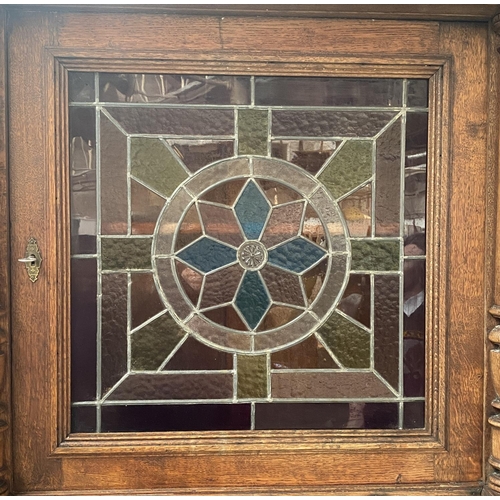 1157 - A late 19th/early 20th century Continental buffet with lead glazed stained glass panel door, over a ... 