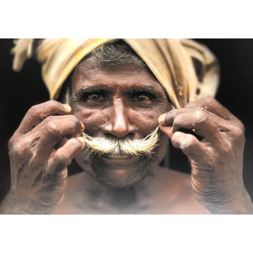 671 - A photographic print on canvas depicting a turbaned gentleman twirling his moustaches, 78x110cm