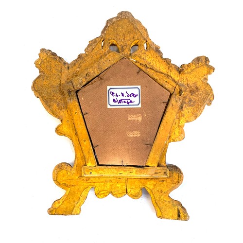 574 - An early 20th century mirror with shaped plate in an ornate giltwood frame surmounted by a basket of... 