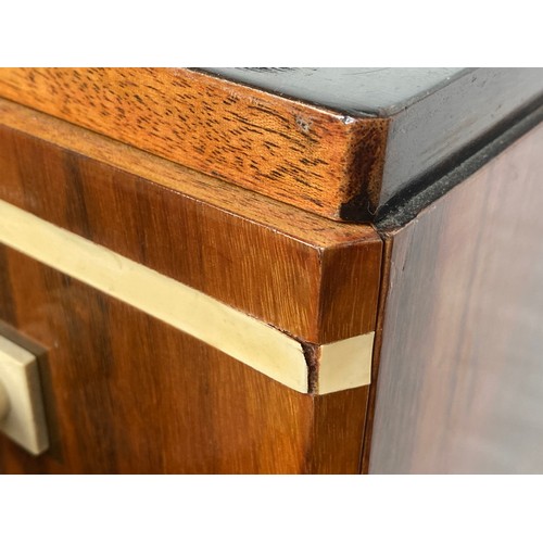 703 - A French Art Deco maccasar ebony pedestal chest, stepped top, over a pair of cupboard doors and an a... 