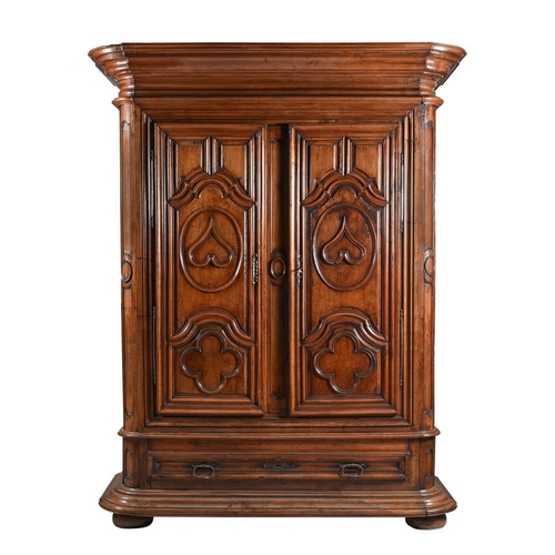 971 - A massive 18th century Continental walnut armoire, the two doors heavily moulded with hearts and qua... 