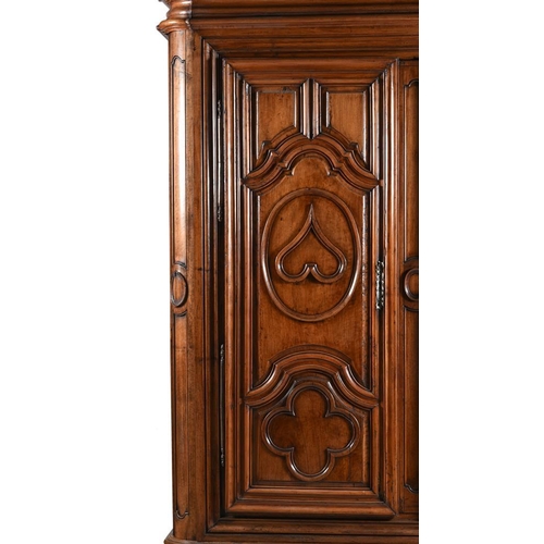 971 - A massive 18th century Continental walnut armoire, the two doors heavily moulded with hearts and qua... 