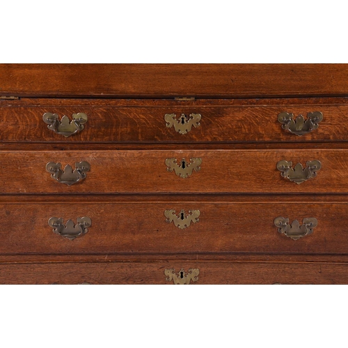 975 - A George III oak bureau bookcase, the fall enclosing a fitted interior, over four graduating drawers... 