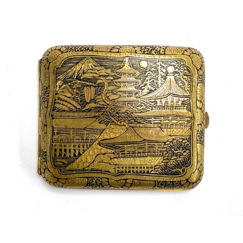 253 - A Japanese damascene style brass cigarette case, one side depicting pagodas and Mt. Fuji, the other ... 