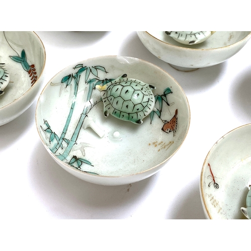 230 - A set of twelve early 20th century Japanese porcelain novelty sake cups, each with moving turtle, 3.... 