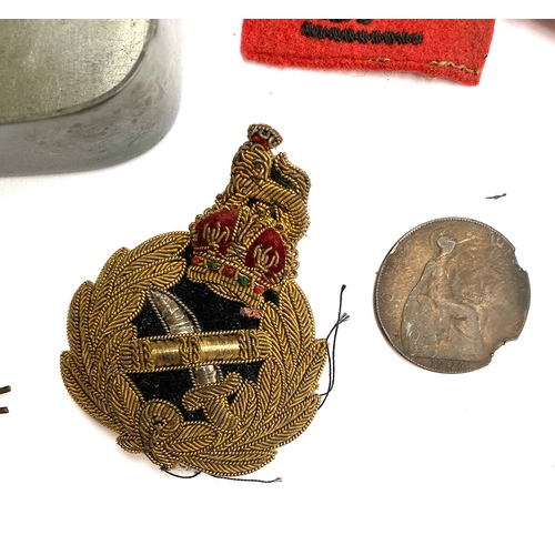 320 - A tin containing military regimental badges, 'Malborough College Corps', Royal Navy artillery badge ... 