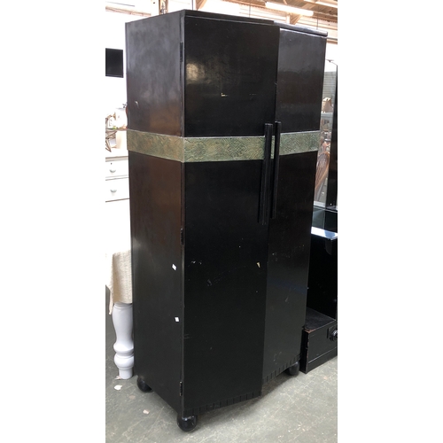 844 - An early 20th century black painted Art Deco wardrobe with applied metal banded decoration, the cant... 