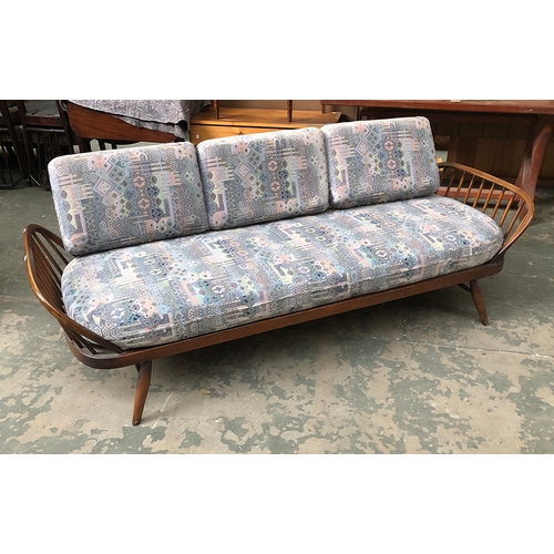 889 - An Ercol three piece suite comprising two stickback armchairs and a sofa with solid elm back, 208cmW