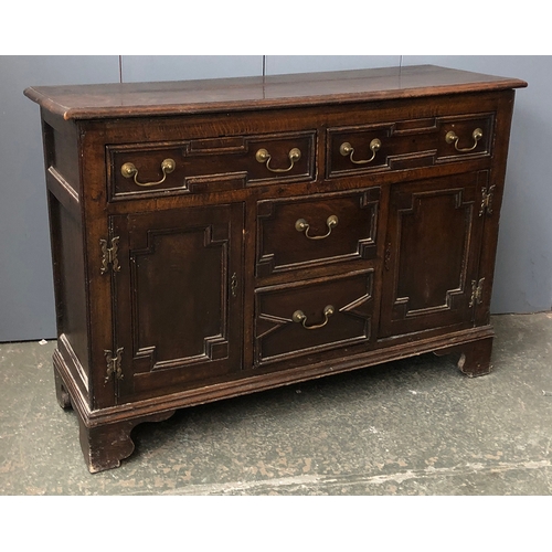 738 - An 18th century and later century oak kitchen dresser, the top with four shelves with pigeon holes a... 