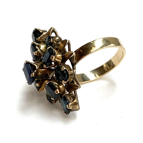 37 - An 18ct gold dress ring set with sapphires in a floral setting, the head of the ring 2.8cmL, size N,... 