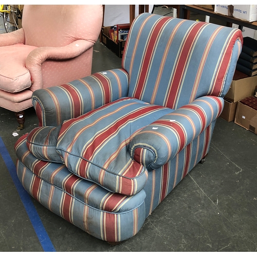 981 - A deep seated country house armchair upholstered in a blue and red striped fabric, feather filled cu... 