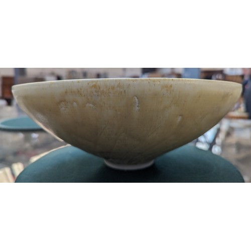 243 - A studio pottery yellow-glazed bowl, indistinctly marked, 27cm wide, together with a parcel cream gl... 