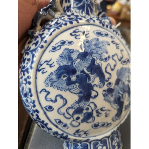 239 - A Chinese blue and white porcelain moon flask, decorated with foo lions amongst ruyi clouds within a... 