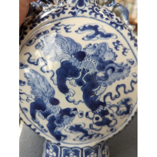 239 - A Chinese blue and white porcelain moon flask, decorated with foo lions amongst ruyi clouds within a... 