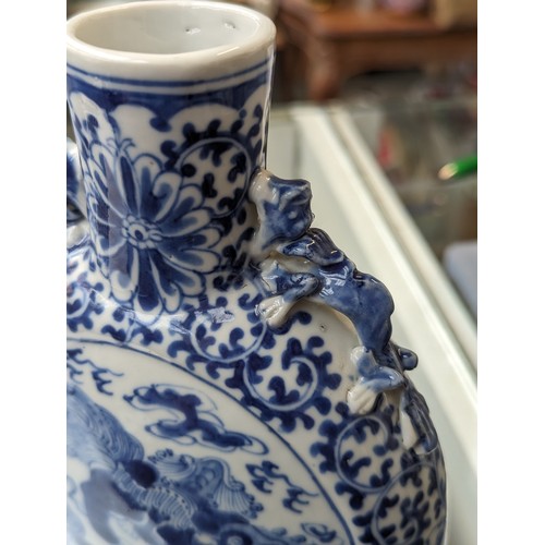 239 - A Chinese blue and white porcelain moon flask, decorated with foo lions amongst ruyi clouds within a... 