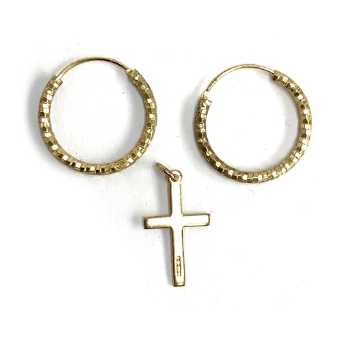 10 - A 9ct gold crucifix, approx. 0.6g; together with silver gilt hoop earrings