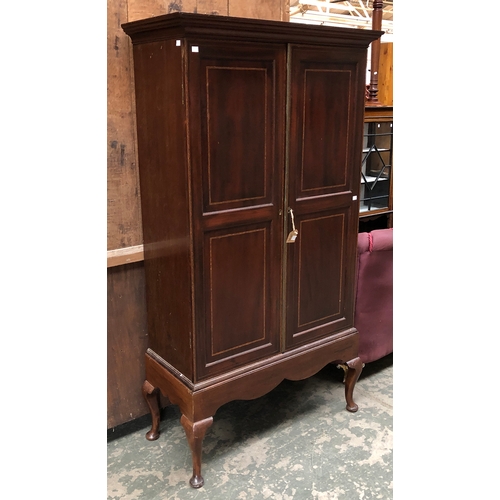 712 - An early 20th century mahogany inlaid gun cabinet, two doors opening to an arrangement of shelves an... 