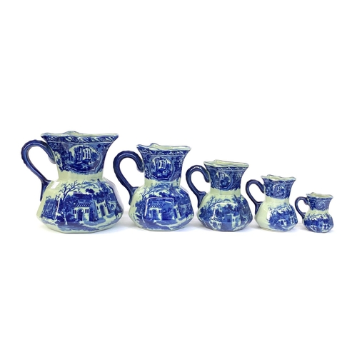 135 - Interior design interest: a set of five graduating blue and white ironstone china jugs, from 23cm to... 