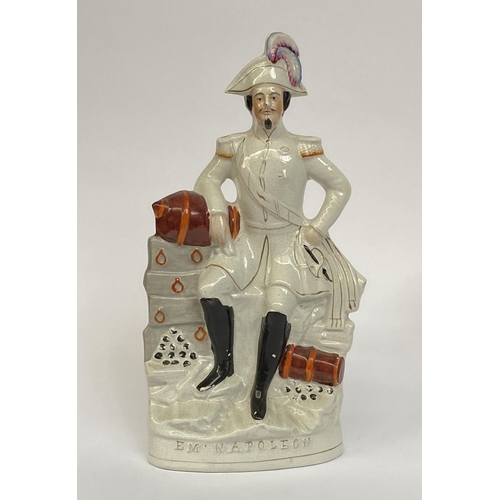 142 - A 19th century Staffordshire flatback figurine of Napoleon, modelled in military uniform beside cann... 